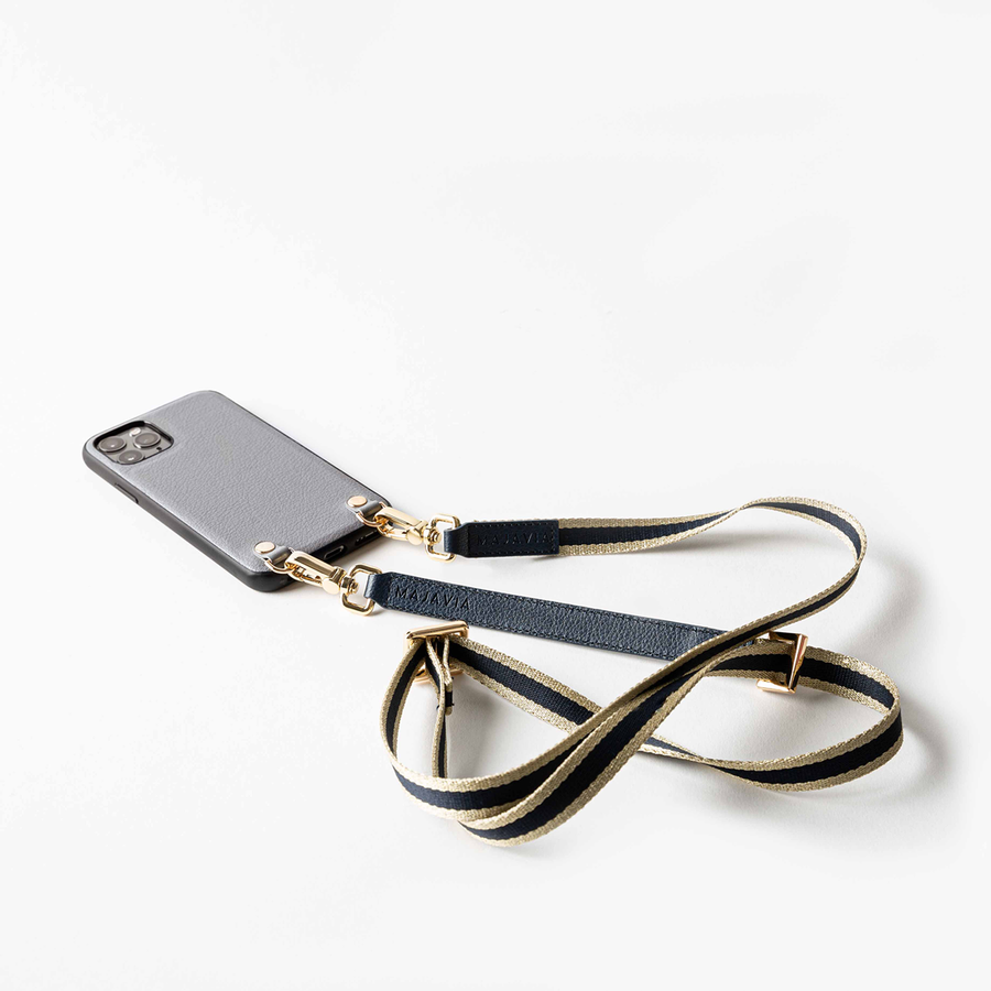 MAJAVIA Strap mit Crossbody iPhone Case in Grau - Schulterriemen in Dunkelblau mit goldenen Details und Streifen in Gold. Material: Polyester sowie Elemente aus recyceltem Echt-Leder