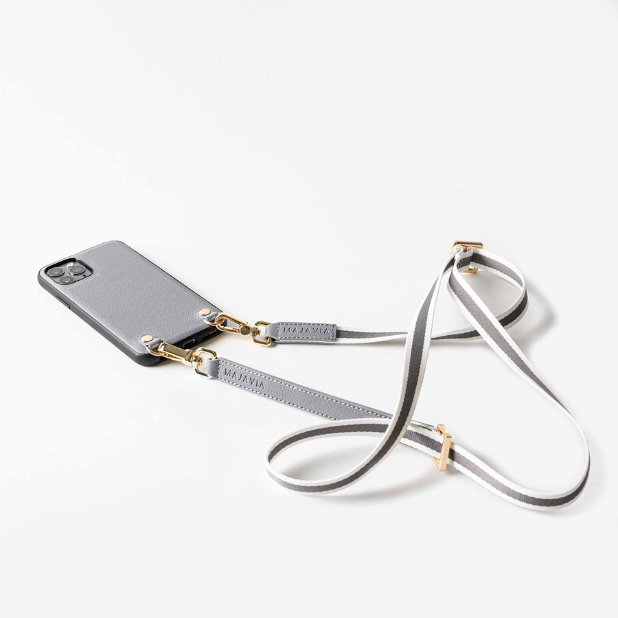 MAJAVIA Strap mit Crossbody iPhone Case in Grau - Schulterriemen in Grau mit goldenen Details und Streifen in Weiß. Material: Polyester sowie Elemente aus recyceltem Echt-Leder